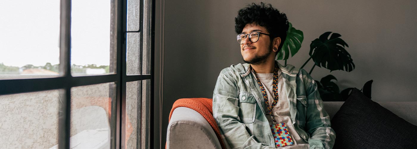 A man wearing glasses is sitting comfortably on a couch.