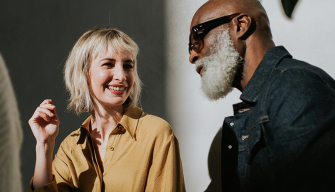 A man and woman engage in conversation, facing each other with attentive expressions.