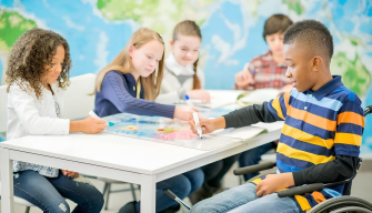 A diverse group of children and a teacher engage in inclusive early childhood education activities in a classroom.