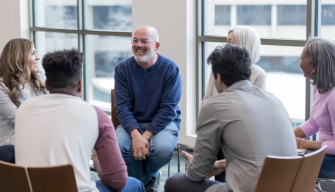 A supportive mental health social worker engages with clients in a professional setting in Australia.