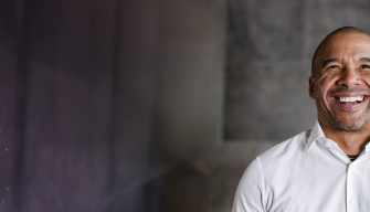 1. A smiling man wearing a white shirt, exuding a friendly and approachable demeanor.