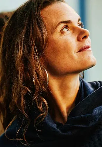 A woman gazes upward at a group of people gathered above her.