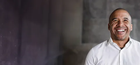 1. A smiling man wearing a white shirt, exuding a friendly and approachable demeanor.