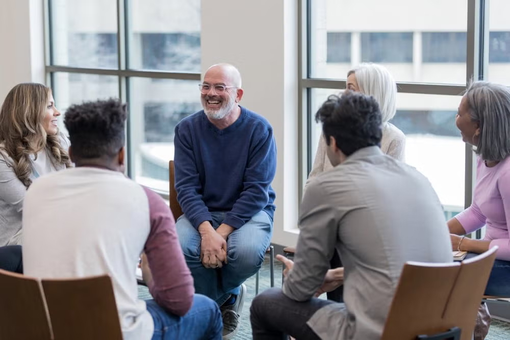 A supportive mental health social worker engages with clients in a professional setting in Australia.