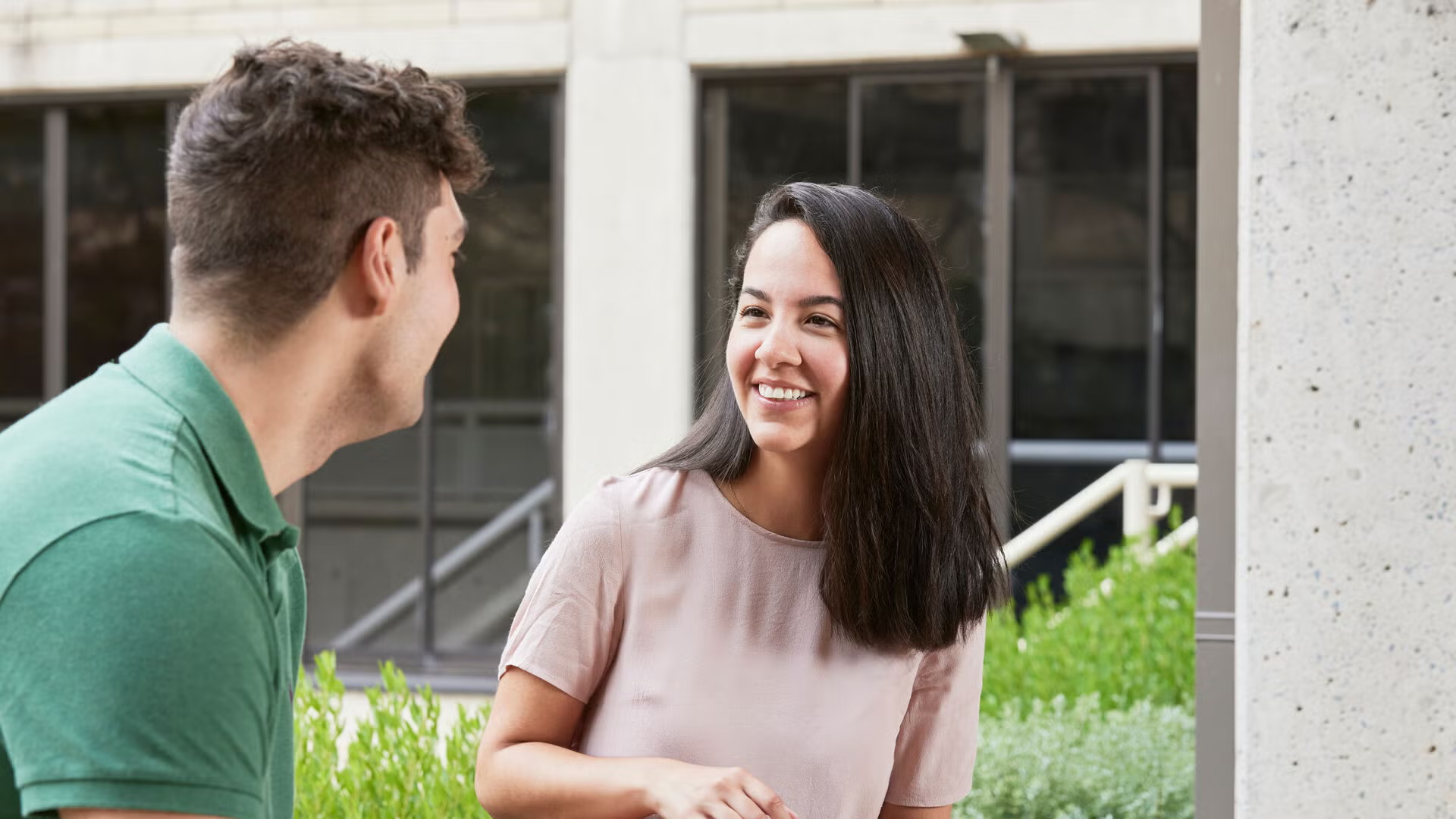 A male student chats with a female peer outdoors on campus, representing reasons to study public policy online
