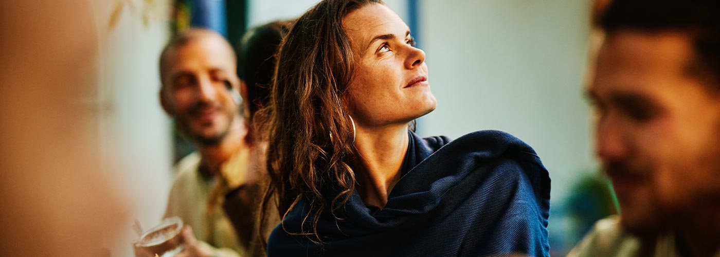 A woman gazes upward at a group of people gathered above her.
